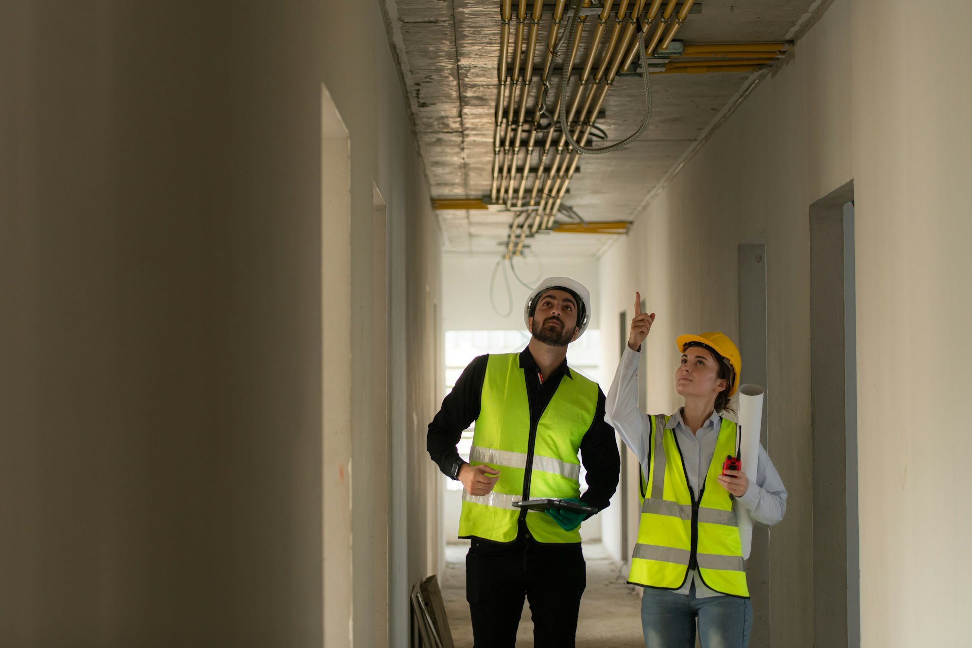 Male and female engineers working on construction site,